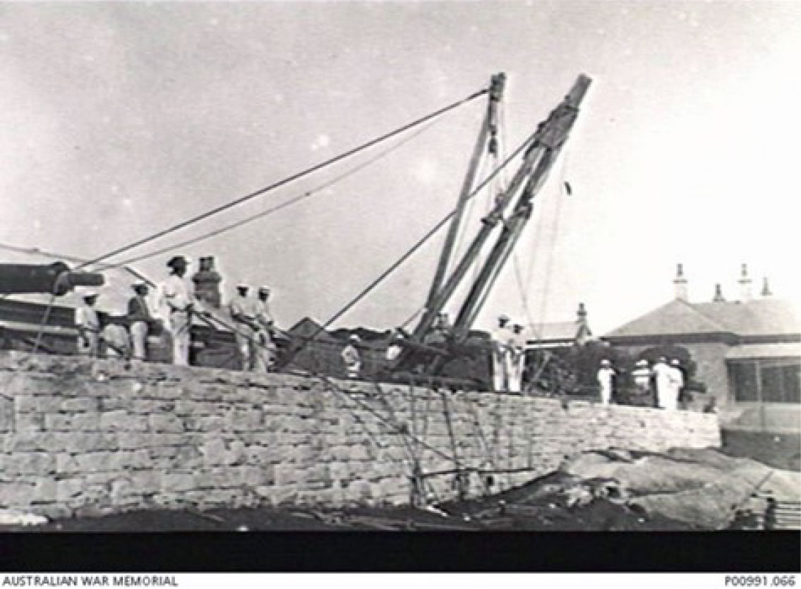 1897. At South Head long course members of the NSW school of gunnery operating shear legs on the edge of the Gun Park. The building at the right edge of the photograph is the Officers Mess. (donor Royal Australian Artillery Historical Society)